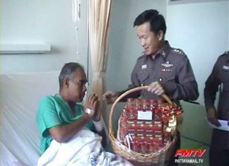 Injured police senior sergeant major Thatpong Thongthat receives a gift from Chonburi Provincial Police Maj. Gen. Thanet Pinmuangam